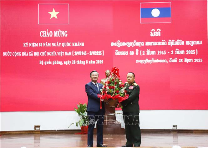 Thượng tướng Thongloi Silivong (bên phải), Thứ trưởng Bộ Quốc phòng Lào tặng hoa cảm ơn Đại sứ Việt Nam tại Lào Nguyễn Minh Tâm đã chia sẻ về ý nghĩa lịch sử của Lễ kỷ niệm 80 năm Quốc khánh Việt Nam. Ảnh: Xuân Tú - PV TTXVN tại Lào