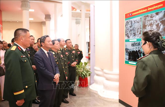 Đại sứ Việt Nam tại Lào Nguyễn Minh Tâm cùng lãnh đạo và cán bộ Bộ Quốc phòng Lào tham quan Triển lãm. Ảnh: Xuân Tú - PV TTXVN tại Lào