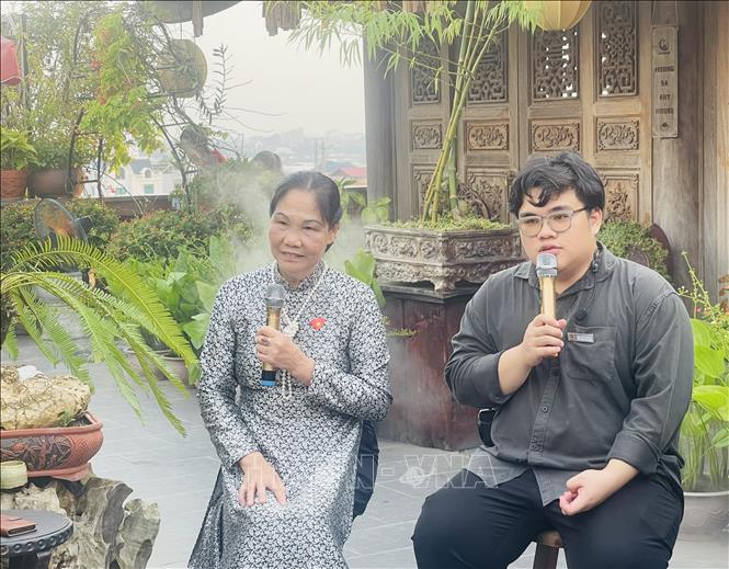 Nghệ nhân Hà Thị Vinh giới thiệu với các phóng viên về nghề gốm Bát Tràng. Ảnh: Tuyết Mai - TTXVN 