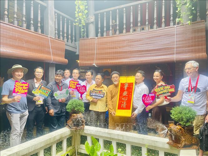 Các phóng viên quốc tế chụp ảnh lưu niệm tại làng nghề Bát Tràng (Hà Nội).  Ảnh: Tuyết Mai - TTXVN 