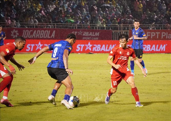 Pha tranh bóng của cầu thủ Công an TP. Hồ Chí Minh (áo đỏ) và CLB Hoàng Anh Gia Lai (áo xanh). Ảnh: Trung Tuyến - TTXVN