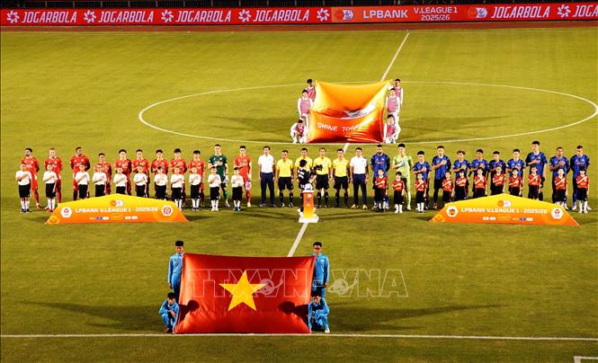 Hai CLB Công an TP. Hồ Chí Minh (áo đỏ) và CLB Hoàng Anh Gia Lai (áo xanh) thực hiện nghi thức chào cờ. Ảnh: Trung Tuyến - TTXVN