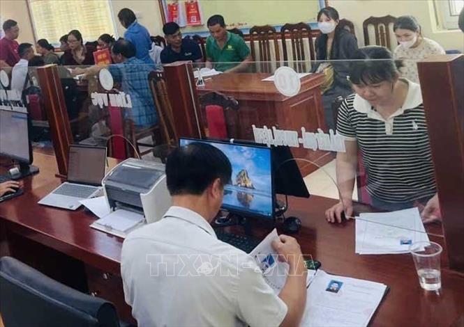 Cán bộ Trung tâm Phục vụ hành chính công xã Lạc Lương giải quyết hồ sơ thủ tục hành chính cho người dân. Ảnh: Vũ Hà - TTXVN