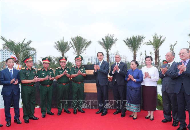 Các đại biểu thực hiện nghi thức kéo băng đặt đá tượng trưng cụm tượng tri ân các chuyên gia Trung Quốc. Ảnh: Trọng Đức - TTXVN