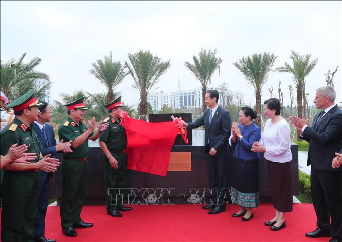 Các đại biểu thực hiện nghi thức kéo băng đặt đá tượng trưng cụm tượng tri ân các chuyên gia Trung Quốc. Ảnh: Trọng Đức - TTXVN