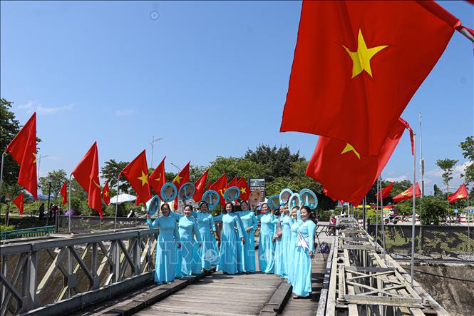 Cầu Mường Thanh được trang hoàng lộng lẫy cờ Tổ quốc thu hút đông đảo người dân, du khách đến chụp ảnh. Ảnh: Phan Quân - TTXVN