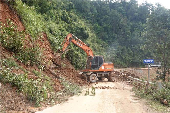 Công ty Cổ phần xây dựng đường bộ I Yên Bái huy động máy móc khắc phục các điểm sạt lở tại Quốc lộ 32. Ảnh: TTXVN phát                                       