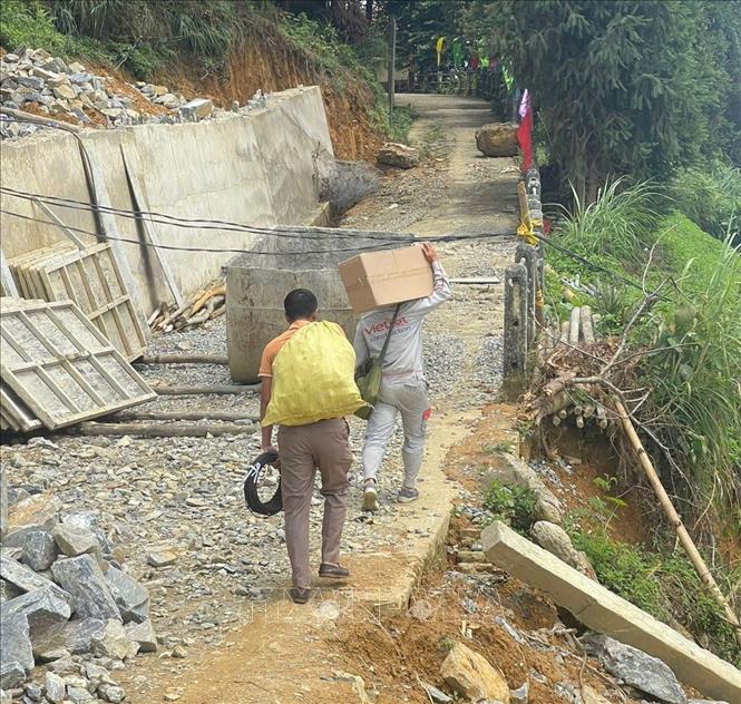 Nhân viên Chi nhánh Viettel Lào Cai vận chuyển thiết bị khắc phục sự cố. Ảnh: TTXVN phát       