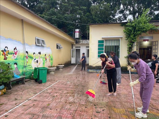 Giáo viên trường mầm non Thiết ống, tỉnh Thanh Hóa dọn dẹp vệ sinh sau bão để đón học sinh tới trường. Ảnh: Nguyễn Nam-TTXVN