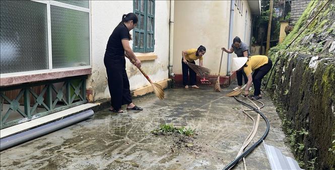 Giáo viên trường mầm non Nam Xuân tỉnh Thanh Hóa dọn dẹp vệ sinh sau bão để đón học sinh tới trường. Ảnh: Nguyễn Nam-TTXVN