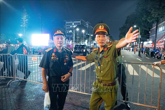 Lực lượng công an làm nhiệm vụ tại khu vực cuối đường Hùng Vương hướng dẫn cựu chiến binh vào vị trí quy định để chờ xem sự kiện. Ảnh: Phạm Tuấn Anh - TTXVN