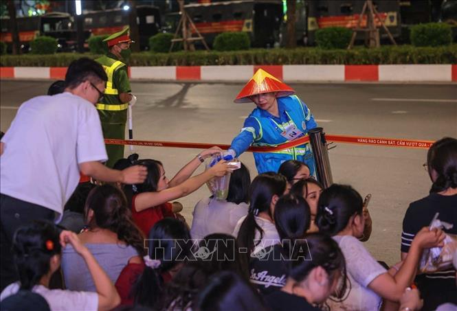 Công nhân môi trường đến tận nơi tập trung người dân hai bên đường để nhận rác, đảm bảo vệ sinh môi trường. Ảnh: Hoàng Hiếu - TTXVN