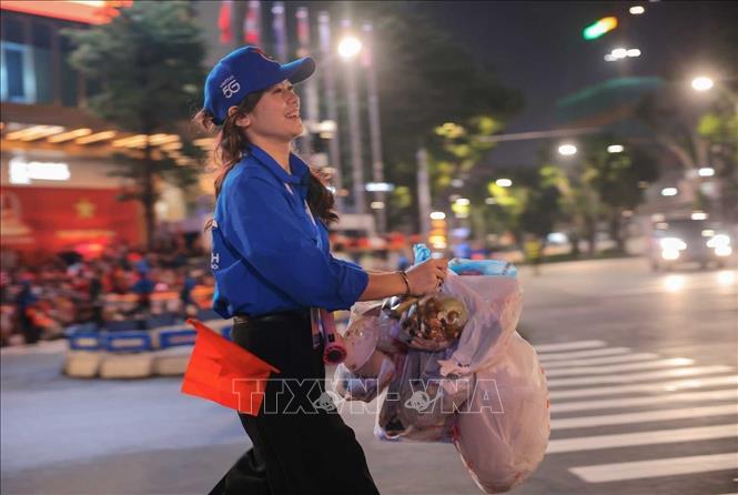 Thanh niên tình nguyện thu gom rác, đảm bảo vệ sinh môi trường tại khu vực đường Văn Cao, đêm 29/8. Ảnh: Hoàng Hiếu - TTXVN