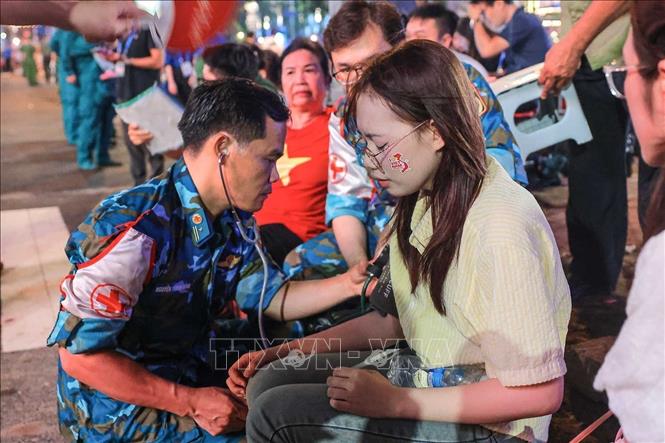 Bác sĩ quân y hỗ trợ kiểm tra sức khoẻ cho người dân bị tụt huyết áp, khó thở khi chờ đợi lâu trong đám dông và thời tiết không thuận lợi trong đêm 29, rạng sáng 30/8. Ảnh: Hoàng Hiếu - TTXVN