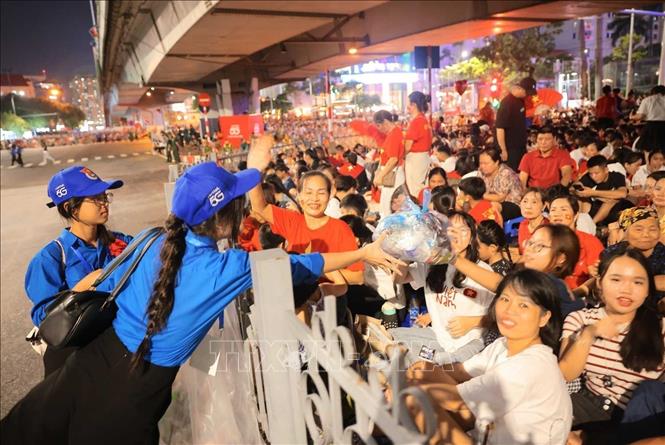 Thanh niên tình nguyện thu gom rác, đảm bảo vệ sinh môi trường tại khu vực đường Văn Cao, đêm 29/8. Ảnh: Hoàng Hiếu - TTXVN