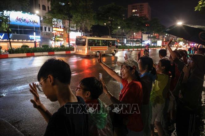 Người dân đón chào đoàn xe chở lực lượng tham gia diễu binh, diễu hành di chuyển qua phố Văn Cao lúc rạng sáng 30/8. Ảnh: Hoàng Hiếu - TTXVN