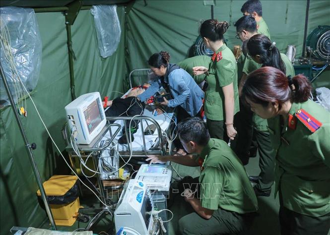 Các bác sĩ của công an Hà Nội khẩn trương sơ cứu cho người dân bị ngã, có hiện tượng co giật khi đi xem lễ diễu binh, diễu hành tại trạm y tế dã chiến phố Liễu Giai. Ảnh: Hoàng Hiếu - TTXVN