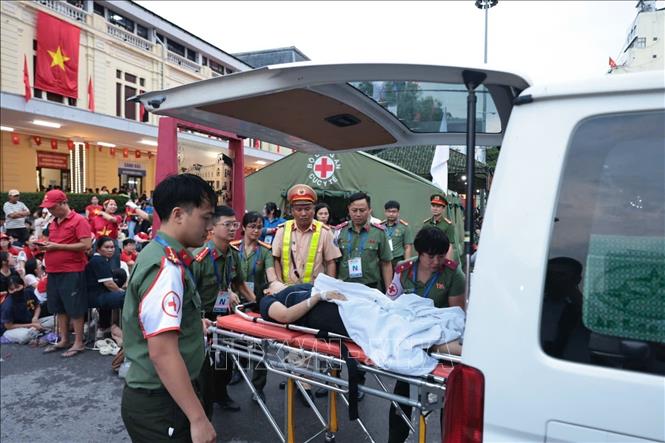 Lực lượng chức năng hỗ trợ chăm sóc sức khỏe một người dân bị ngất trên phố Lê Duẩn (ảnh chụp lúc 5g45 ngày 30/8). Ảnh: Trần Việt - TTXVN