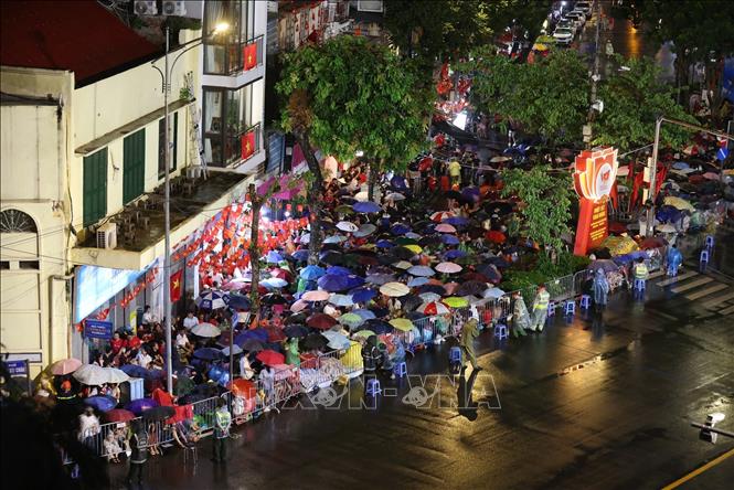 Người dân đội mưa chờ đến giờ tổng duyệt A80. Ảnh: Công Đạt - TTXVN