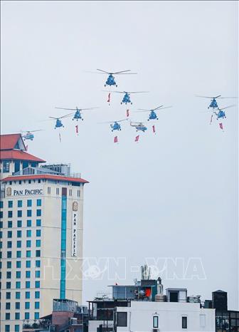 Mở đầu cuộc diễu binh, diễu hành là màn trình diễn của biên đội máy bay trực thăng của Không quân nhân dân mang theo cờ Đảng, cờ Tổ quốc. Ảnh: Khánh Hòa - TTXVN