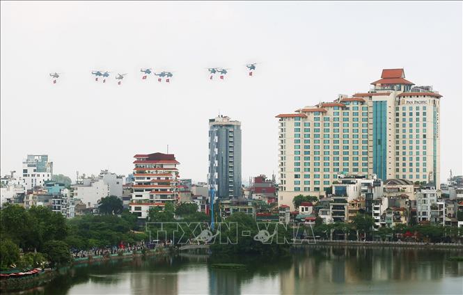Mở đầu cuộc diễu binh, diễu hành là màn trình diễn của biên đội máy bay trực thăng của Không quân nhân dân mang theo cờ Đảng, cờ Tổ quốc. Ảnh: Phạm Kiên - TTXVN