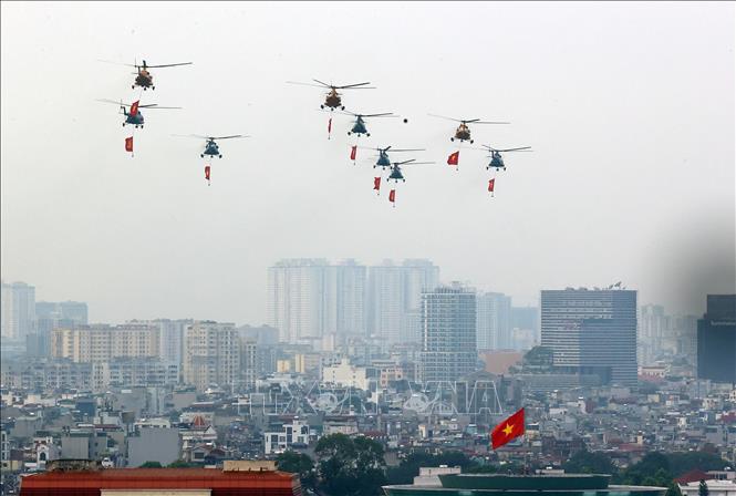 Mở đầu cuộc diễu binh, diễu hành là màn trình diễn của biên đội máy bay trực thăng của Không quân nhân dân mang theo cờ Đảng, cờ Tổ quốc. Ảnh: Huy Hùng - TTXVN