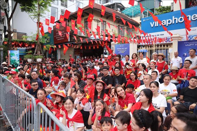 Người dân đứng hai bên đường Nguyễn Thái Học, Cửa Nam, Tràng Thi chào đón đoàn diễu binh, diễu hành. Ảnh: Công Đạt - TTXVN