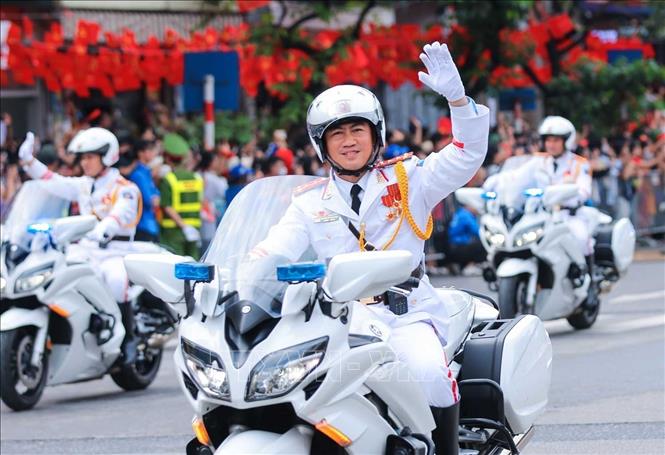 Khối xe bảo vệ hộ tống lãnh đạo Đảng, Nhà nước và đoàn khách quốc tế vẫy chào người dân trên đường Văn Cao. Ảnh: Hoàng Hiếu - TTXVN