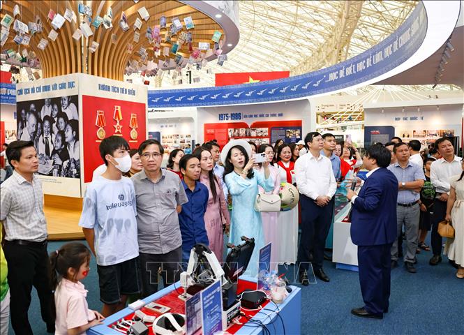 Giới thiệu về khu trưng bày của Bộ Giáo dục và Đào tạo tới khách tham quan. Ảnh: Thanh Tùng - TTXVN