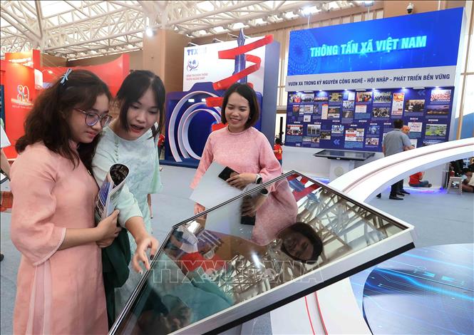 Khách tham quan triển lãm tìm hiểu những thông tin trên các nền tảng số tại gian trưng bày. Ảnh: TTXVN