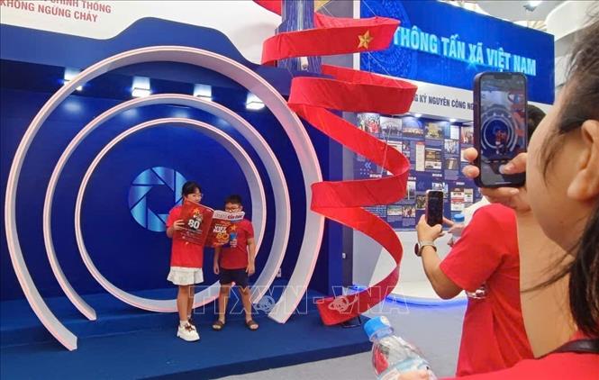 Khách tham quan trải nghiệm và chụp ảnh lưu niệm tại không gian trưng bày của Thông tấn xã Việt Nam. Ảnh: TTXVN