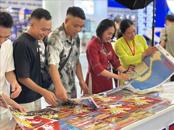 Khách tham quan tìm hiểu, trải nghiệm tại gian hàng của TTXVN. Ảnh: TTXVN 