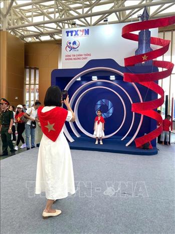 Khách tham quan tìm hiểu, trải nghiệm tại gian hàng của TTXVN. Ảnh: TTXVN 