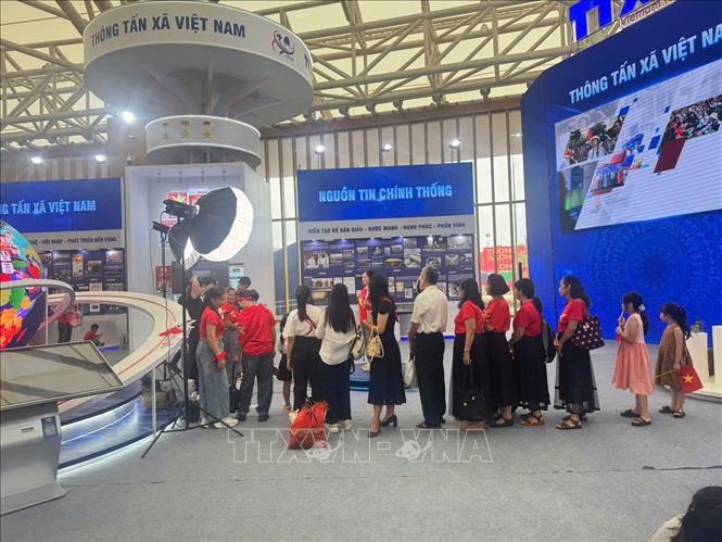 Khách tham quan tìm hiểu, trải nghiệm tại gian hàng của TTXVN. Ảnh: TTXVN 