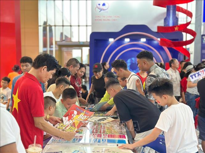 Khách tham quan tìm hiểu, trải nghiệm tại gian hàng của TTXVN. Ảnh: TTXVN 