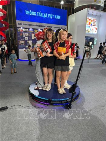 Khách tham quan tìm hiểu, trải nghiệm tại gian hàng của TTXVN. Ảnh: TTXVN 