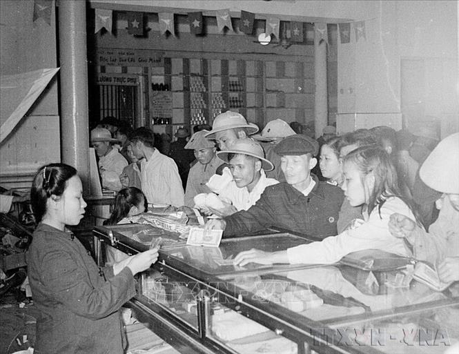 Thực hiện kế hoạch 3 năm lần thứ nhất (1955 - 1957) và 3 năm lần thứ hai (1958 - 1960) đã làm diện mạo miền Bắc thay đổi với sự phục hồi, phát triển của nhiều thành phần kinh tế, đời sống nhân dân dần được nâng cao, trong đó thành phần kinh tế toàn dân và tập thể đóng vai trò chủ đạo trong cơ cấu kinh tế quốc dân. Trong ảnh: Cửa hàng mậu dịch phục vụ Tết Bính Thân 1956 tại Hà Nội. 
Ảnh: TTXVN 
