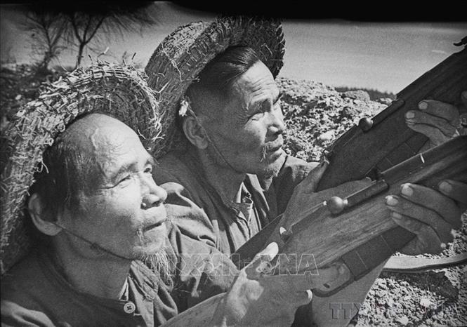 Ngay sau khi Mỹ leo thang, gây chiến tranh phá hoại miền Bắc, Hội nghị Trung ương Đảng lần thứ 11 (3/1965) đã kịp thời đề ra nhiều chủ trương và biện pháp, đảm bảo thực hiện tốt cùng lúc cả hai nhiệm vụ chiến đấu và xây dựng. Trong ảnh: Đơn vị lão dân quân Bạch đầu quân, huyện Hoằng Hóa, tỉnh Thanh Hóa bắn rơi máy bay Mỹ bằng súng bộ binh. Ảnh: Tư liệu TTXVN
