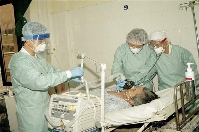 Không chỉ khống chế các dịch bệnh trong nước, Việt Nam là một trong những quốc gia đầu tiên khống chế thành công dịch SARS, cúm A/H5N1, cúm A/H1N1; ngăn chặn thành công không để một số dịch bệnh nguy hiểm mới nổi xâm nhập như cúm A/H7N9, Ebola, MERS-CoV, COVID-19... Trong ảnh: Các bác sĩ Viện Y học Lâm sàng các bệnh nhiệt đới Hà Nội điều trị cho bệnh nhân mắc SARS nặng (2003). Ảnh: Hữu Oai – TTXVN
