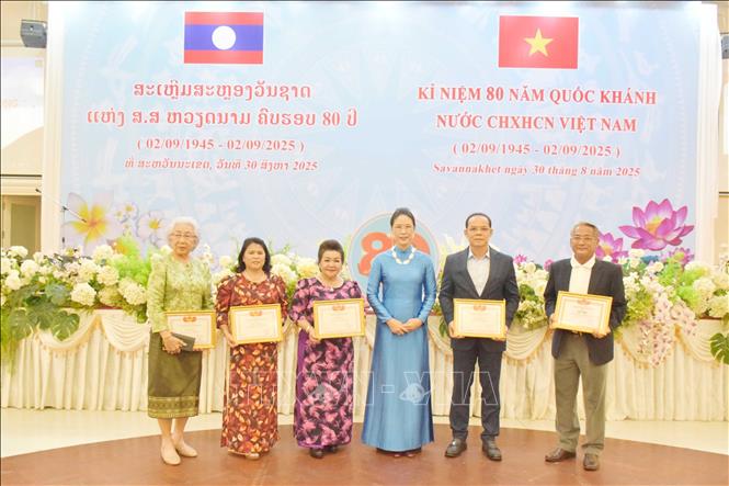 Bà Đặng Thị Hải Tâm, Tổng Lãnh sự Việt Nam tại tỉnh Savannakhet, Trung Lào trao giấy khen cho các kiều bào có thành tích xuất sắc trong việc đoàn kết hướng về quê hương Tổ quốc. Ảnh: TTXVN phát