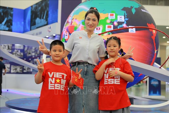 Người dân chụp ảnh lưu niệm tại khu Trưng bày của TTXVN. Ảnh: Khánh Hoà - TTXVN