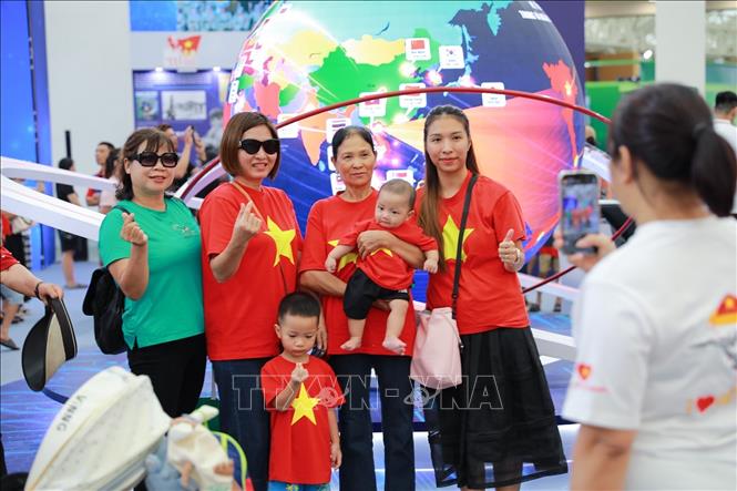 Người dân chụp ảnh lưu niệm tại khu Trưng bày của TTXVN. Ảnh: Khánh Hoà - TTXVN