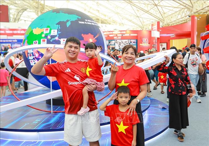 Người dân chụp ảnh lưu niệm tại khu Trưng bày của TTXVN. Ảnh: Khánh Hoà - TTXVN