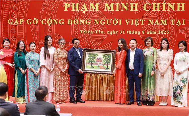Thủ tướng Phạm Minh Chính tặng quà cộng đồng người Việt Nam tại Trung Quốc. Ảnh: Dương Giang-TTXVN
