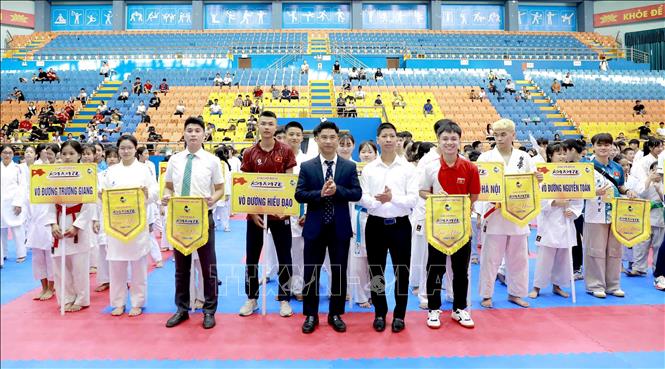 Các đơn vị, câu lạc bộ karate tham gia giải đấu nhận cờ lưu niệm từ ban tổ chức giải đấu. Ảnh: Hoàng Hùng – TTXVN