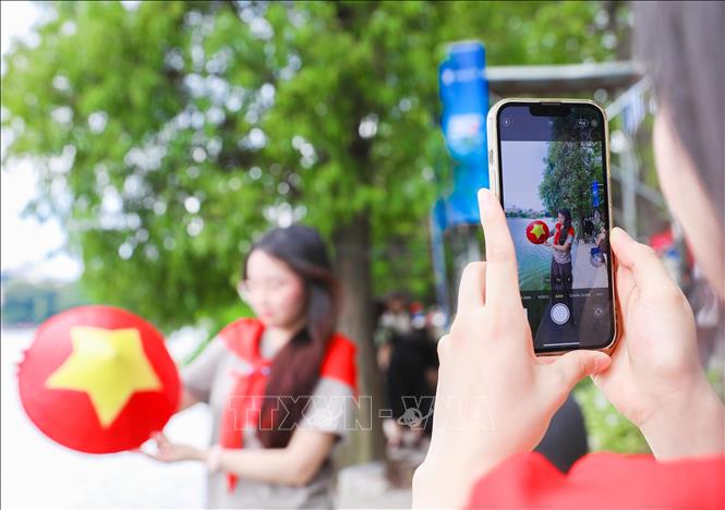 Check-in trong sắc cờ đỏ sao vàng, người dân lưu lại khoảnh khắc ý nghĩa cùng Tháp Rùa cổ kính. Ảnh: Thành Phương – TTXVN
