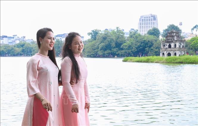 Người dân rạng rỡ chụp ảnh tại khu vực hồ Hoàn Kiếm. Ảnh: Thành Phương - TTXVN