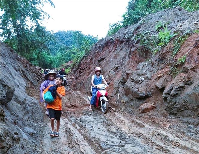 Người dân và các phương tiện qua lại điểm sạt lở trên quốc lộ 48 tại bản Na Lướm (xã Thông Thụ, tỉnh Nghệ An) sau khi tuyến đường được thông tuyến. Ảnh: TTXVN phát