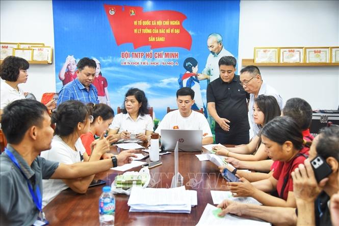 Người dân đến đăng ký nhận quà tại điểm chi trả phường Bồ Đề (Hà Nội). Ảnh: Minh Quyết - TTXVN