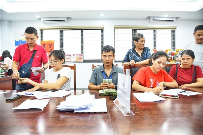 Người dân đến đăng ký nhận quà tại điểm chi trả phường Bồ Đề (Hà Nội). Ảnh: Minh Quyết - TTXVN